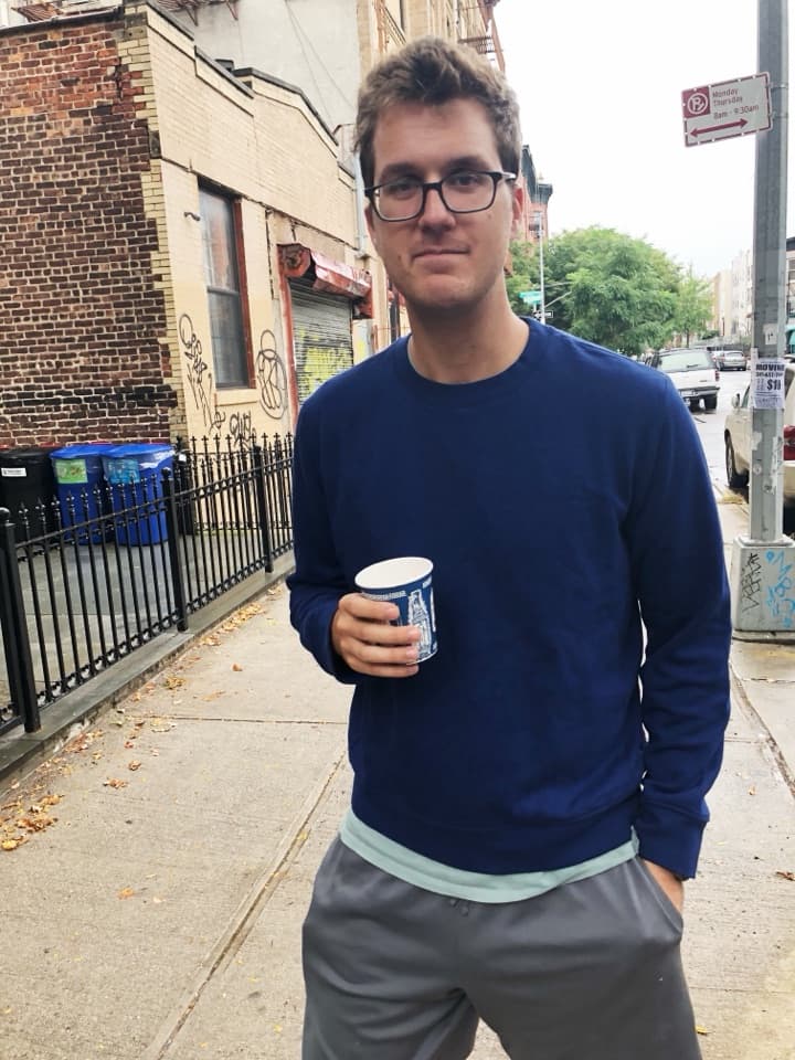 Robbie Sherrard, founder of Flex Bundles, holding a coffee on a city sidewalk